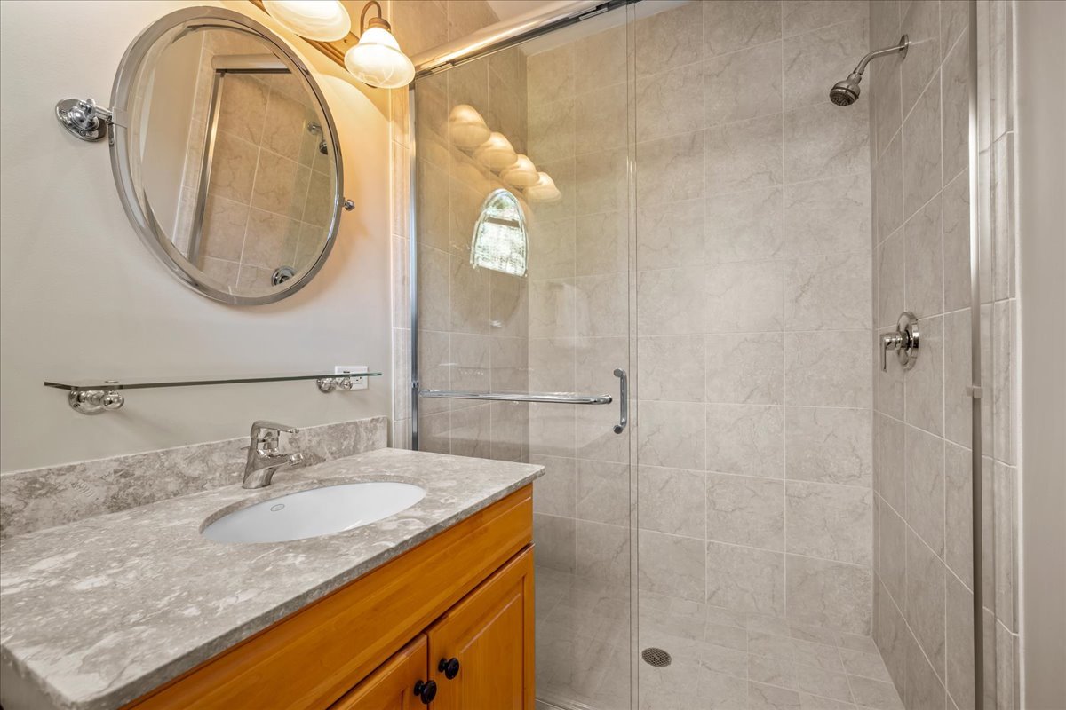 738 Lyster Road Highwood, IL 60040 - Photo 9 of 16 a bathroom with a granite countertop sink a mirror and a shower