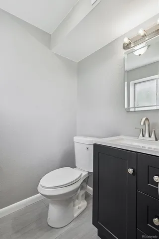 a bathroom with a toilet a sink and mirror