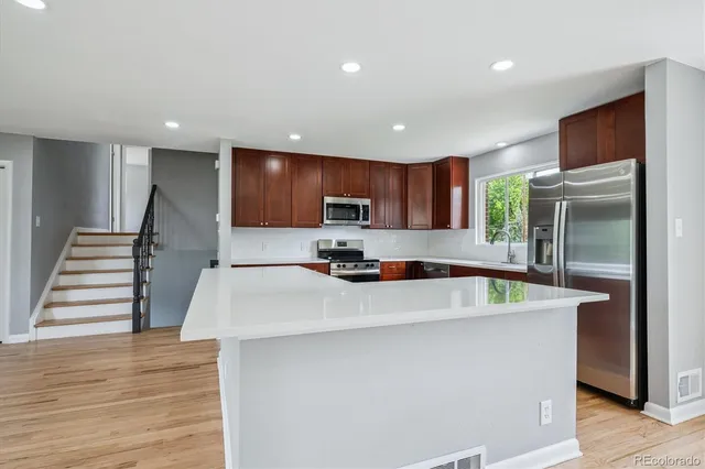 a kitchen with kitchen island a sink stainless steel appliances and cabinets
