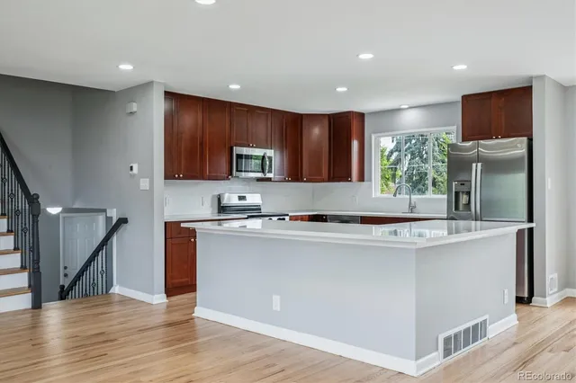 a kitchen with stainless steel appliances granite countertop a refrigerator sink and cabinets