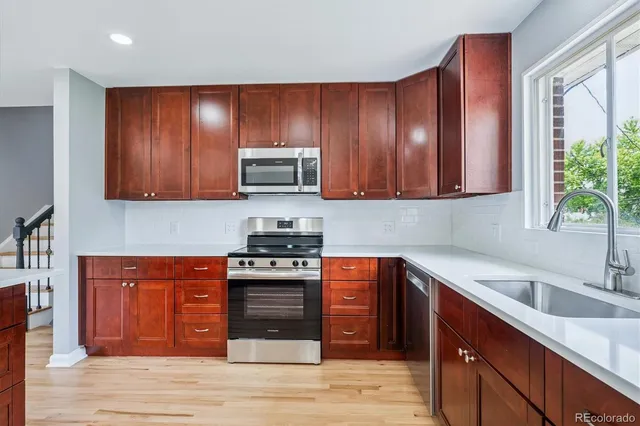 a kitchen with stainless steel appliances granite countertop wooden cabinets a stove top oven a sink and dishwasher