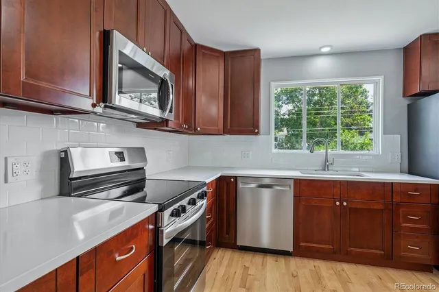 a kitchen with wooden cabinets and a stove top oven