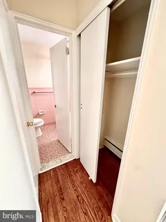 a view of room with wooden floor and a bathroom