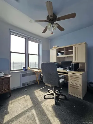 a view of a workspace with furniture and a window
