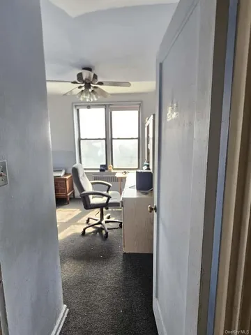 a view of a workspace with furniture and a window