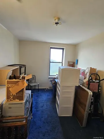 a living room with a bed and a dresser