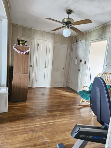 a view of a livingroom with furniture wooden floor and a ceiling fan