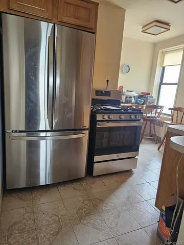 a kitchen with stainless steel appliances granite countertop a refrigerator a stove and a sink