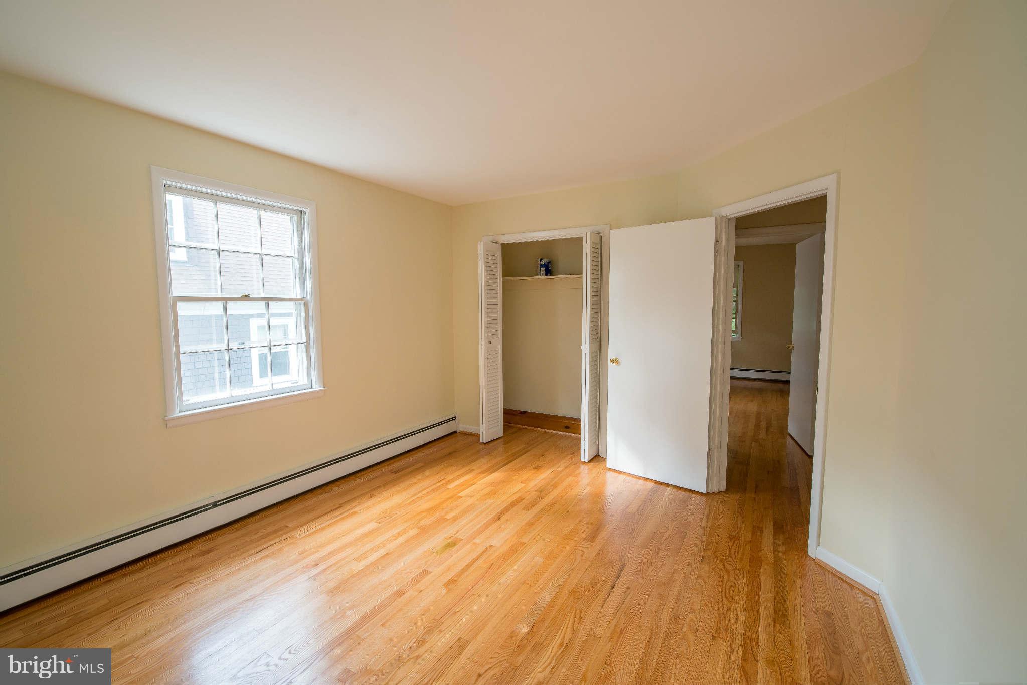 5 Beechdale Road Baltimore, MD 21210 - Photo 11 of 20 a view of an empty room with wooden floor and a window