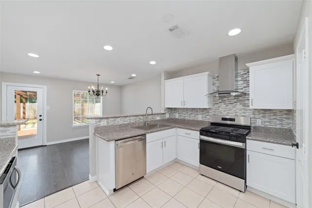 a kitchen with stainless steel appliances granite countertop a stove a sink and a refrigerator