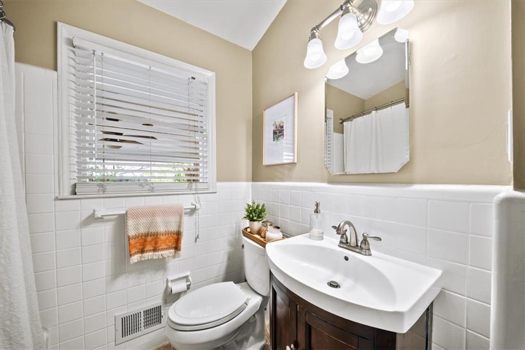 109 Spruell Springs Road Atlanta, GA 30342 - Photo 19 of 34 a bathroom with a sink a toilet and mirror