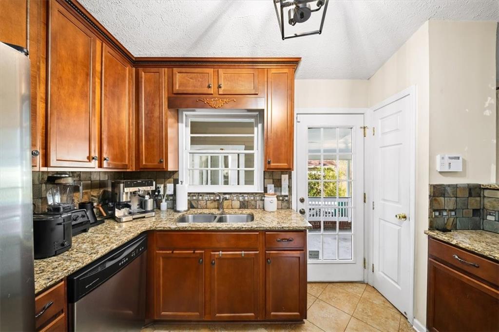 109 Spruell Springs Road Atlanta, GA 30342 - Photo 10 of 34 a kitchen with large window wooden cabinets and stainless steel appliances