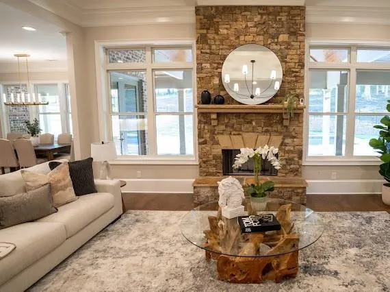a living room with furniture a fireplace and a large window