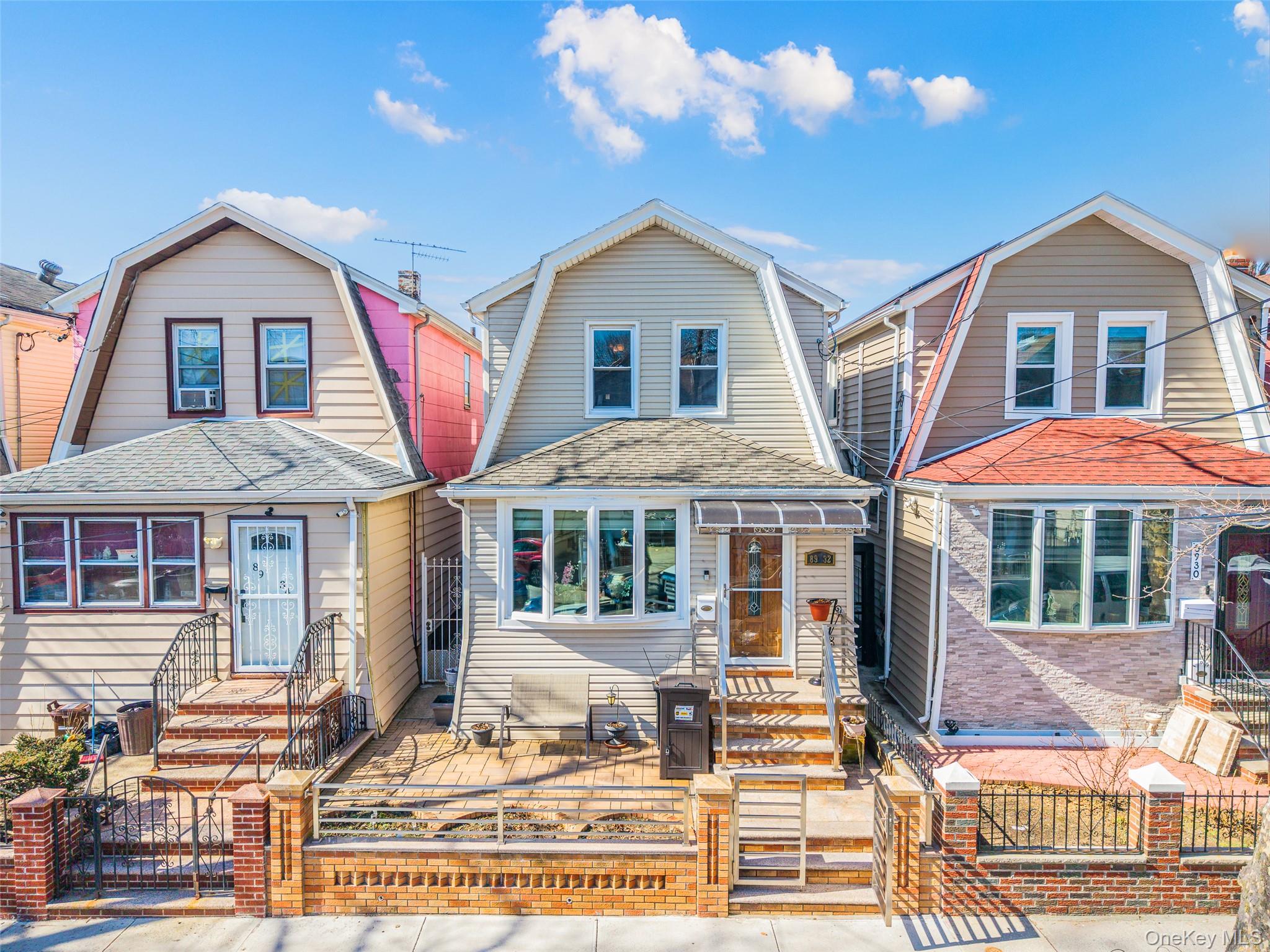 89-32 90th Street Queens, NY 11421 - Photo 1 of 33 Dutch colonial featuring a gambrel roof, a gate, a fenced front yard, and roof with shingles