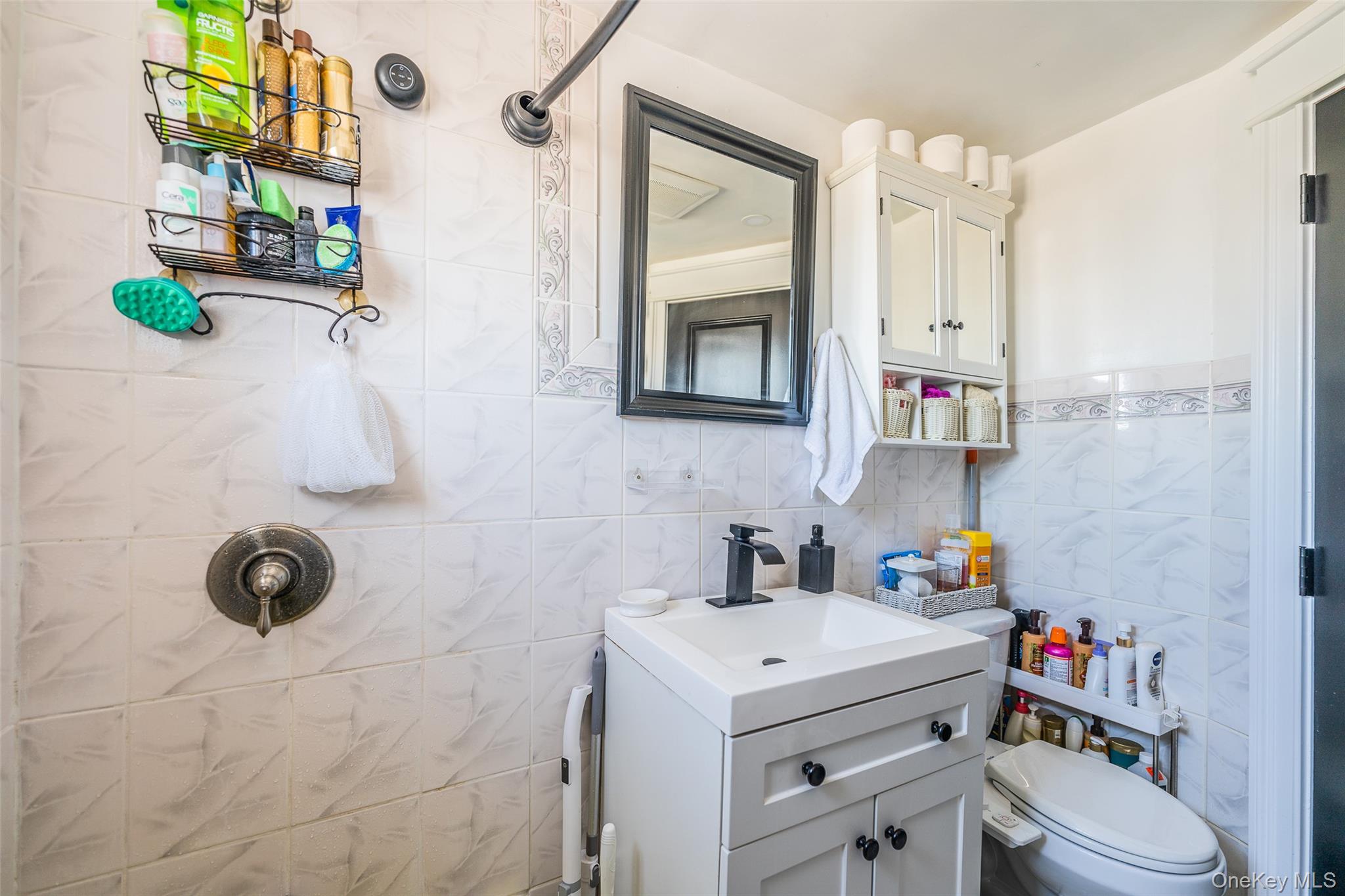 89-32 90th Street Queens, NY 11421 - Photo 15 of 33 Bathroom with vanity, tile walls, and a tile shower
