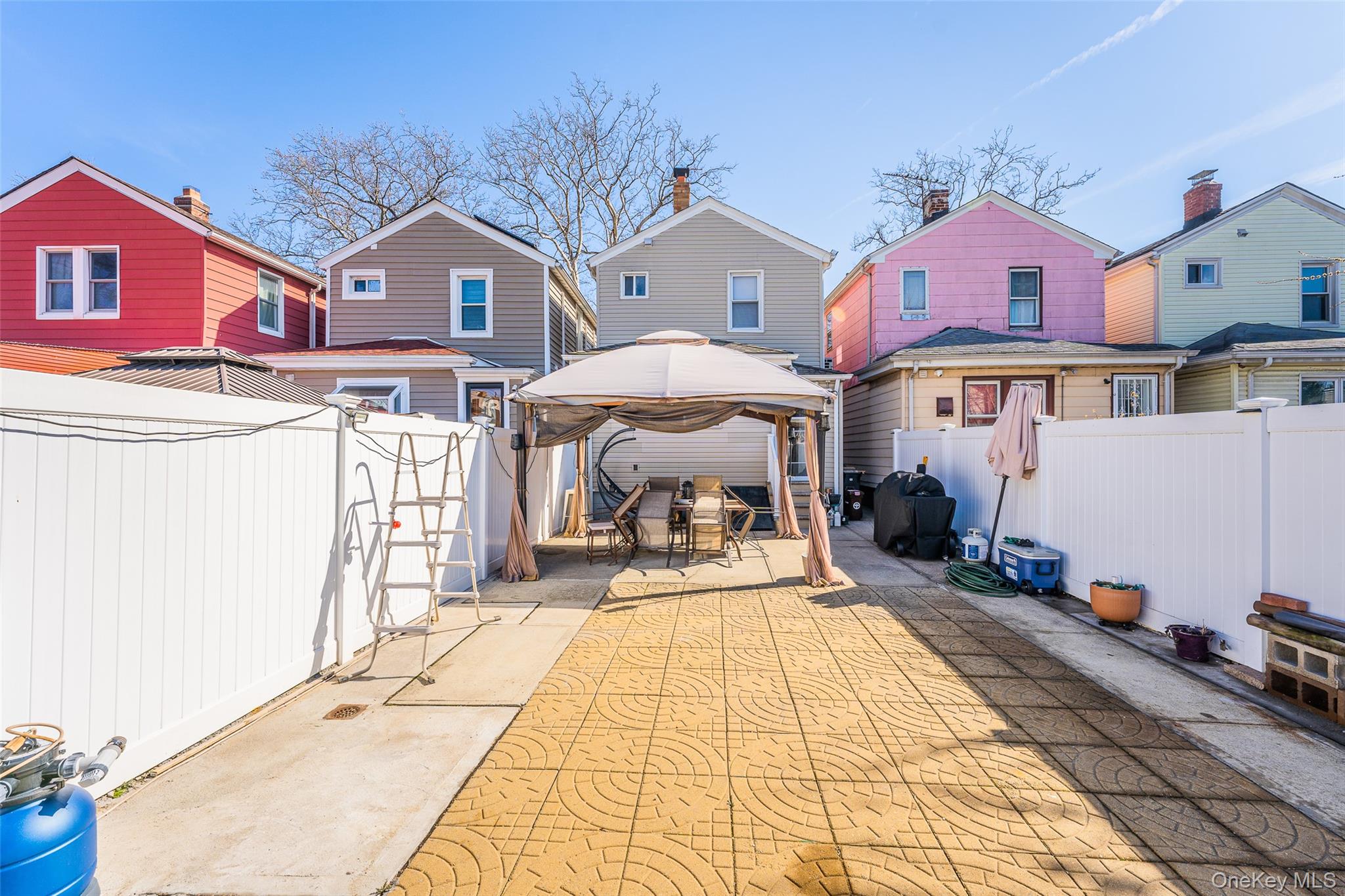 89-32 90th Street Queens, NY 11421 - Photo 22 of 33 Back of house with a gazebo, a patio area, a fenced backyard, and a residential view