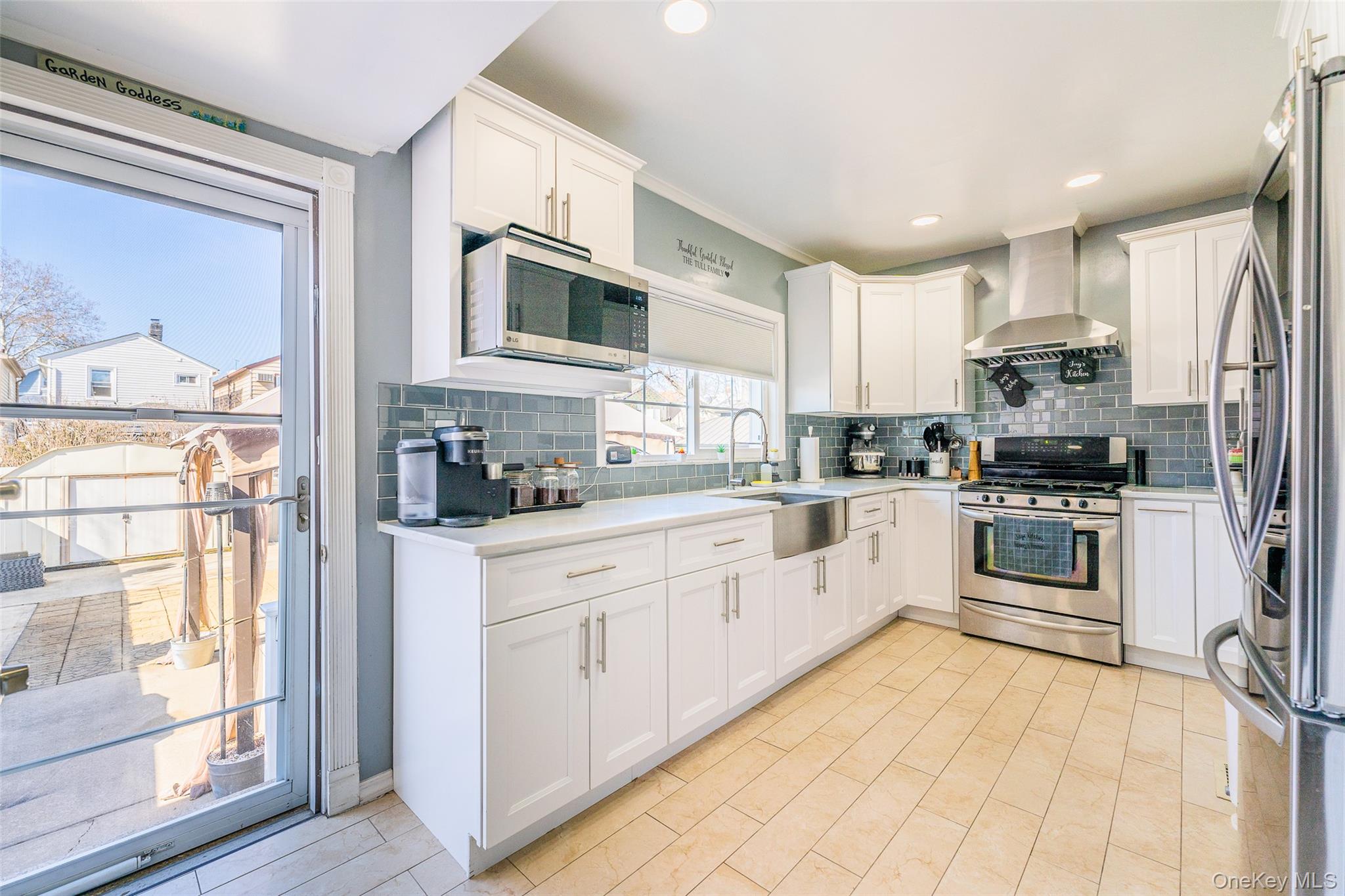 89-32 90th Street Queens, NY 11421 - Photo 3 of 33 Kitchen with white cabinetry, stainless steel appliances, ornamental molding, tasteful backsplash, and recessed lighting
