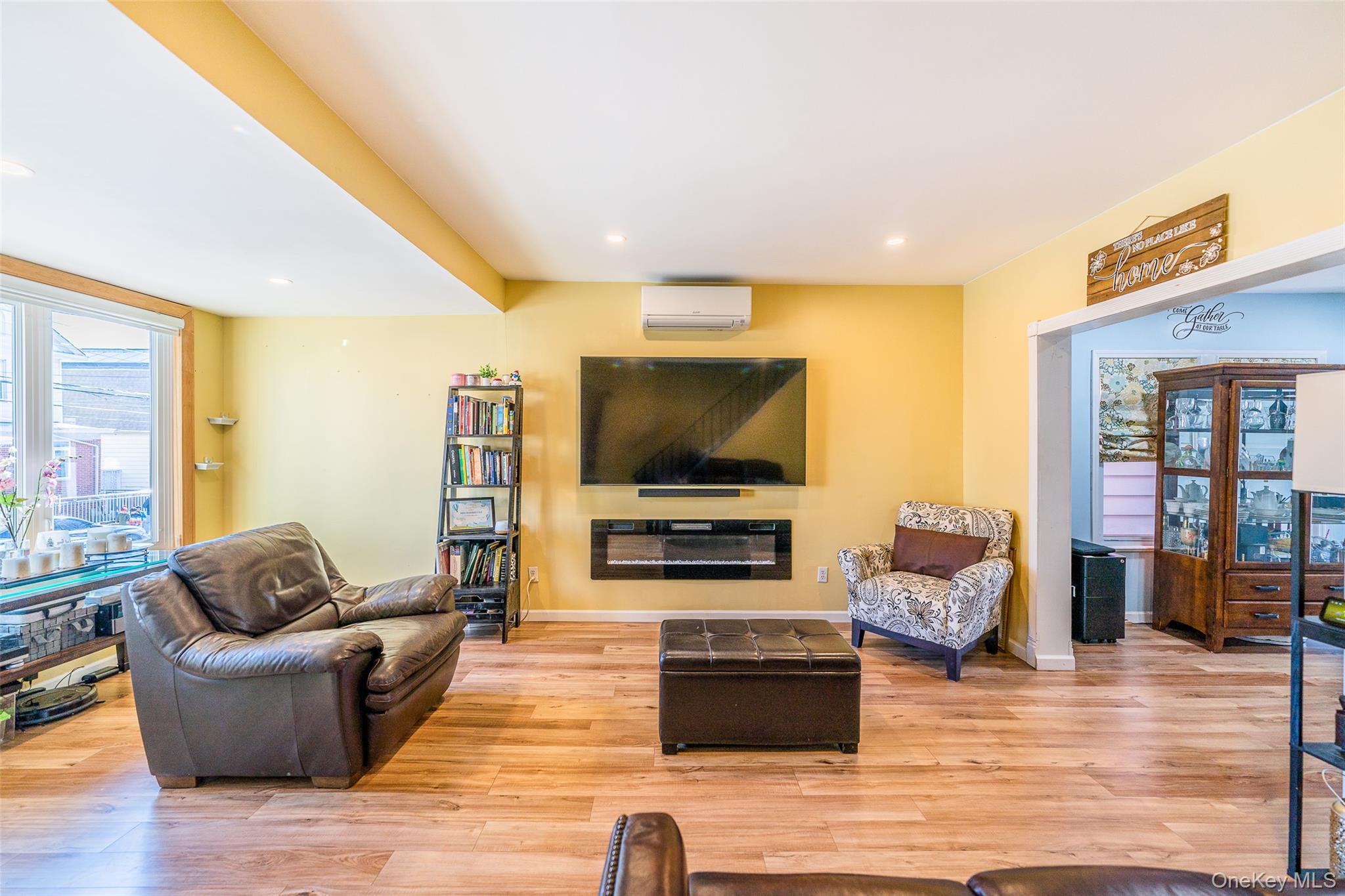 89-32 90th Street Queens, NY 11421 - Photo 10 of 33 Living room with light wood finished floors, a glass covered fireplace, and recessed lighting