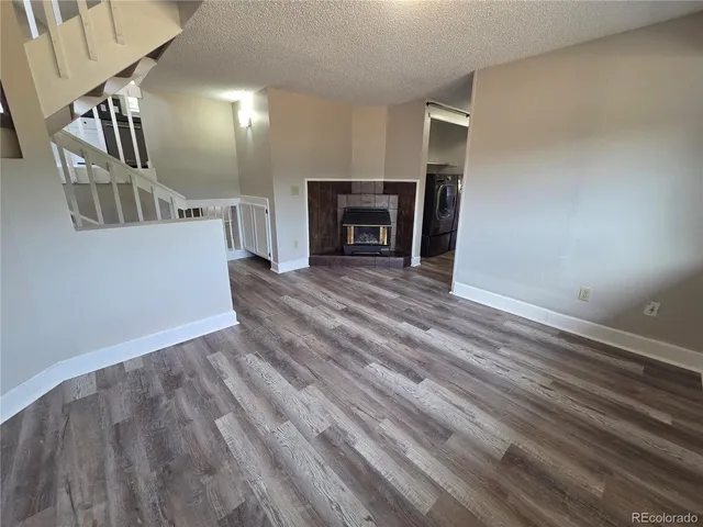 a view of a livingroom with wooden floor and a fireplace