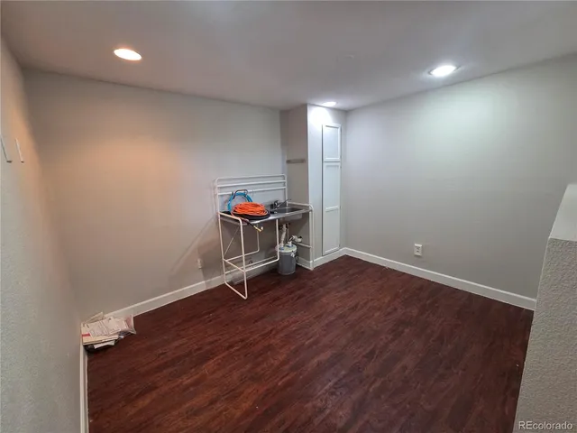an empty room with wooden floor and chair