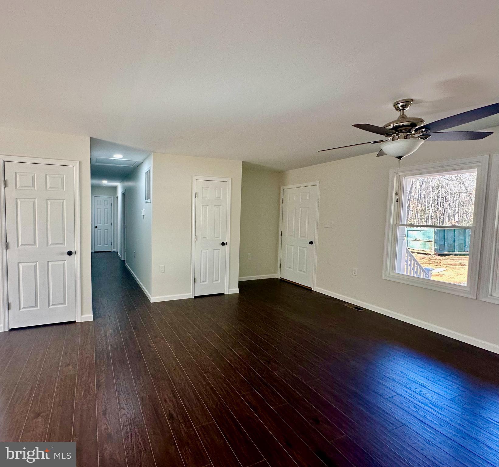 17094 Bel Pre Road Culpeper, VA 22701 - Photo 2 of 7 an empty room with wooden floor chandelier fan and windows