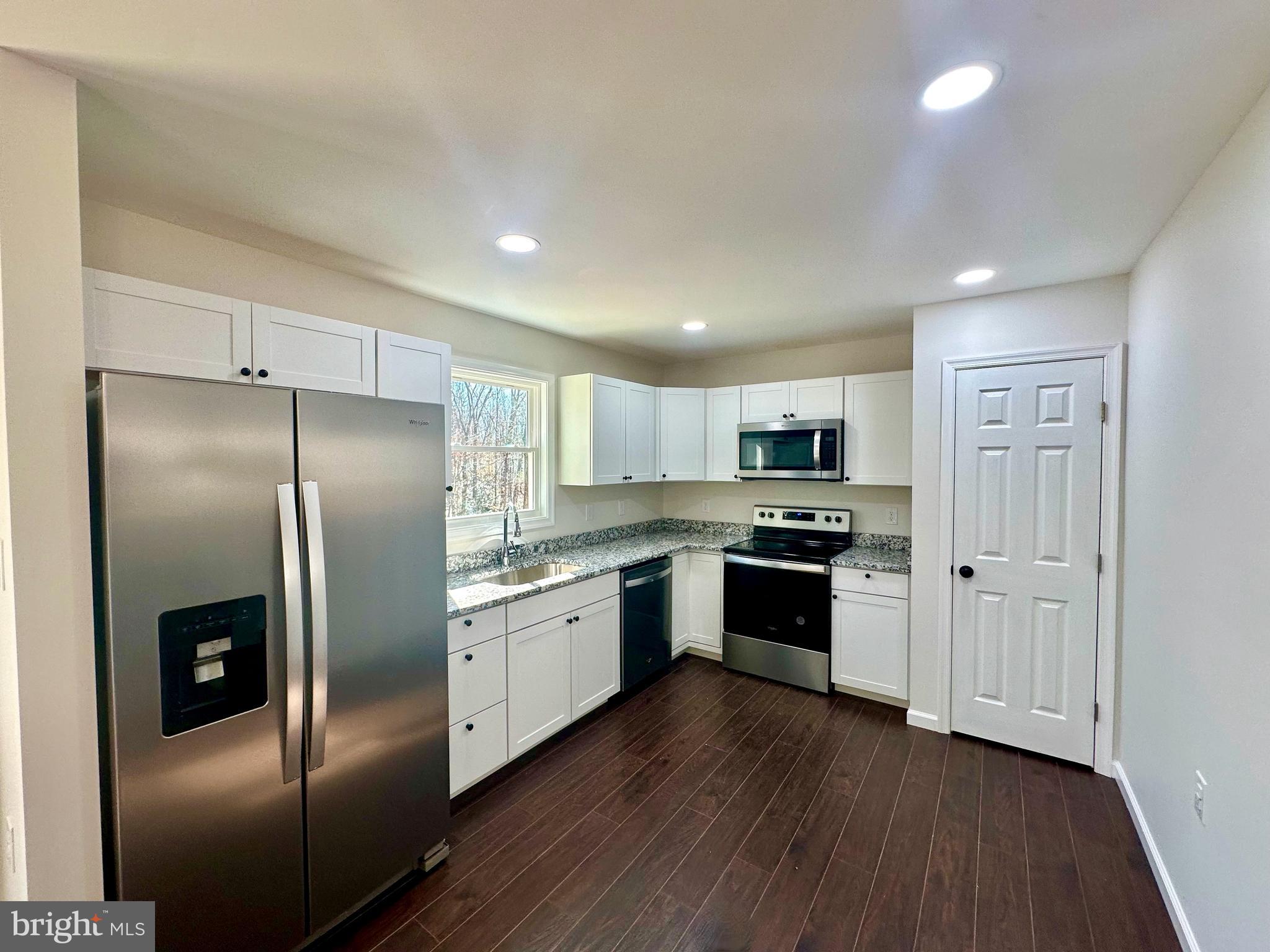 17094 Bel Pre Road Culpeper, VA 22701 - Photo 4 of 7 a large kitchen with stainless steel appliances granite countertop a refrigerator and a stove top oven