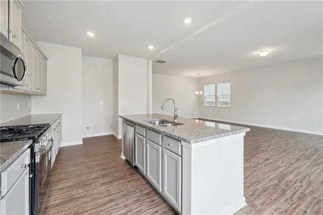 a kitchen with granite countertop a sink and a stove top oven