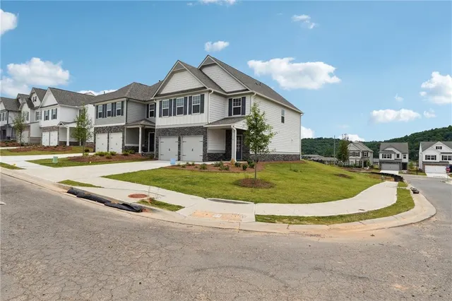 a view of a white house with a yard and plants