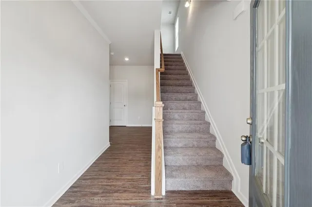 a view of a hallway with wooden floor and staircase