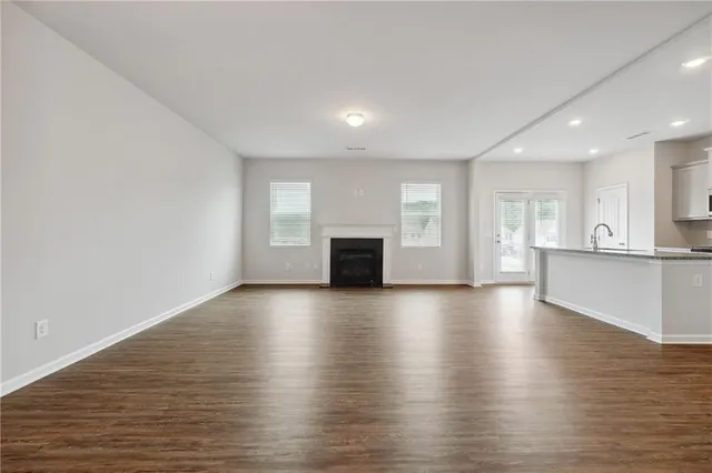 a view of empty room with wooden floor and fireplace