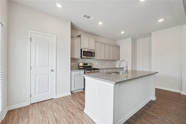 a kitchen with stainless steel appliances granite countertop a stove a sink and a refrigerator