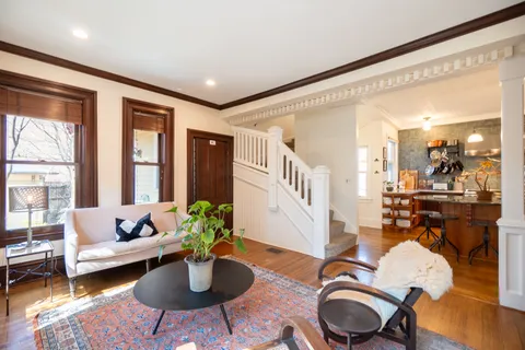a kitchen with stainless steel appliances kitchen island granite countertop a sink a refrigerator and wooden floor