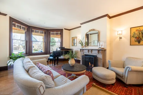 a living room with furniture a fireplace and a large window
