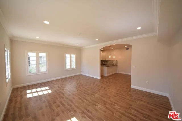 a view of empty room with wooden floor and window
