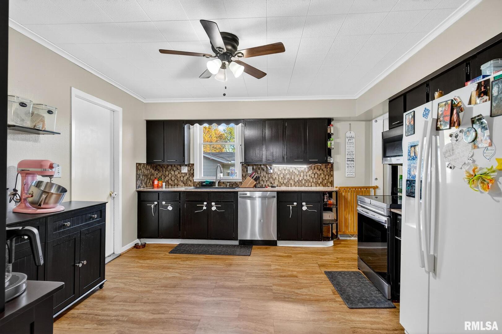 919 9th Avenue Fulton, IL 61252 - Photo 31 of 54 a kitchen with stainless steel appliances kitchen island granite countertop a refrigerator cabinets and wooden floor