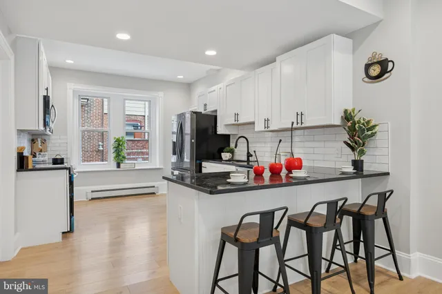 a kitchen with stainless steel appliances kitchen island granite countertop a refrigerator and microwave