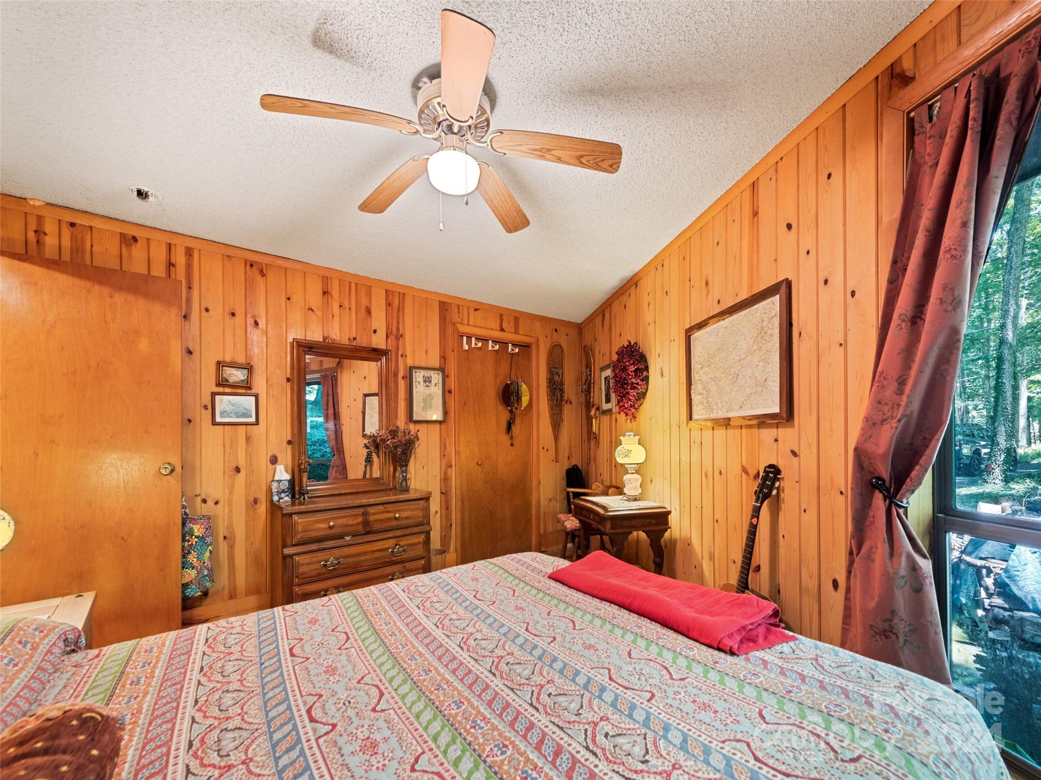 1004 Old Country Road Waynesville, NC 28786 - Photo 24 of 30 a bedroom with a bed and a chandelier