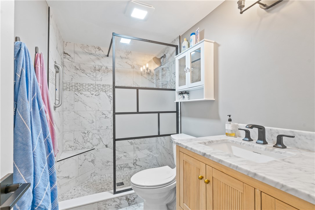 275 Date Palm Road, Unit 307 Vero Beach, FL 32963 - Photo 20 of 36 a bathroom with a granite countertop sink toilet and shower