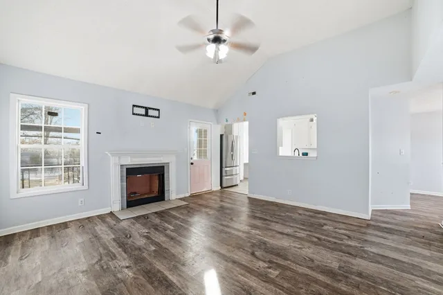 an empty room with windows fireplace and a sink