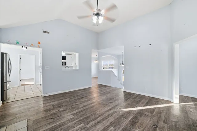 a view of empty room with wooden floor and ceiling fan