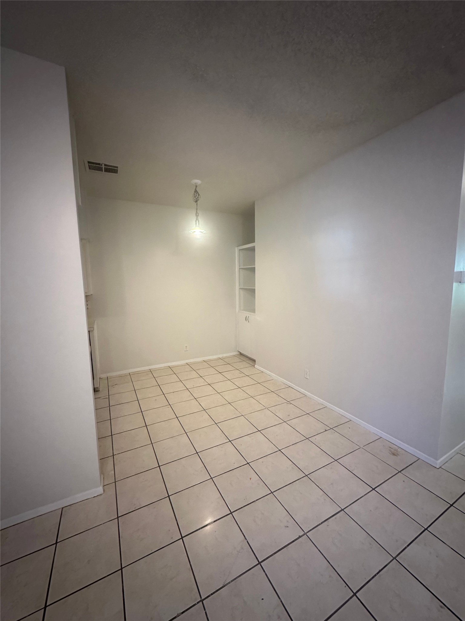 106 East 30th Street, Unit 101 Austin, TX 78705 - Photo 5 of 11 Unfurnished room with light tile patterned floors and built in shelves