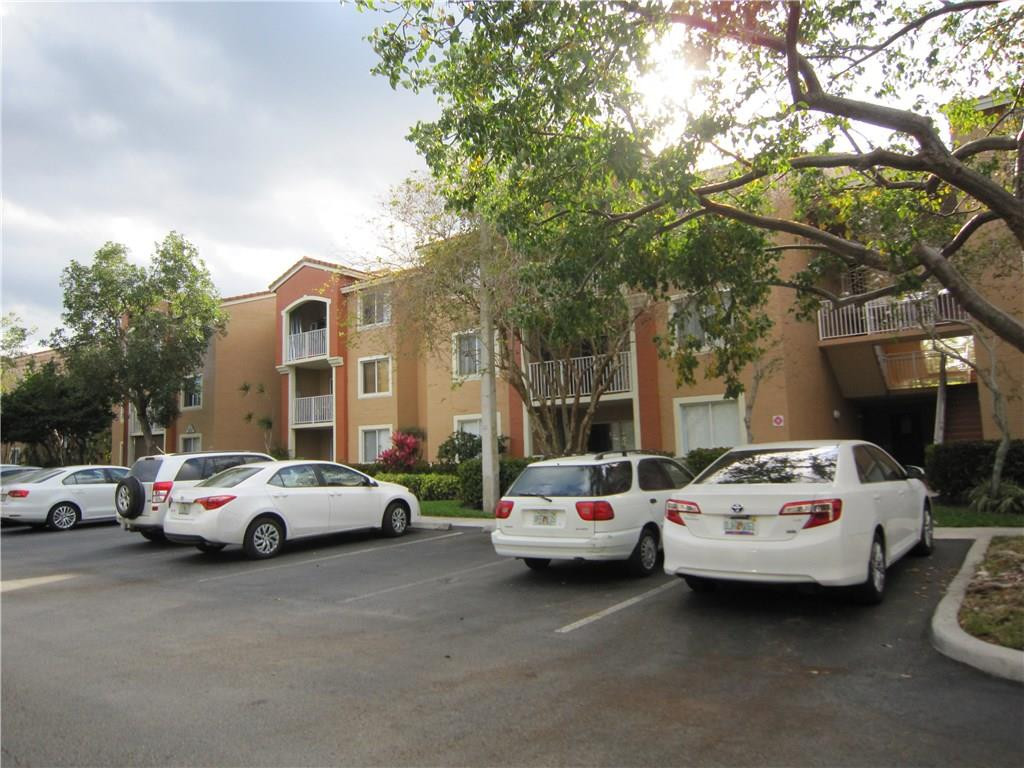 3874 Lyons Road, Unit 2036 Coconut Creek, FL 33073 - Photo 1 of 16 a white car parked in front of a house