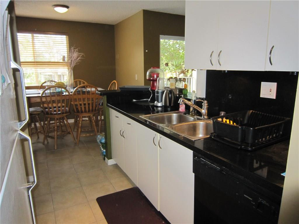 3874 Lyons Road, Unit 2036 Coconut Creek, FL 33073 - Photo 11 of 16 a kitchen with granite countertop a sink a counter top space and stainless steel appliances