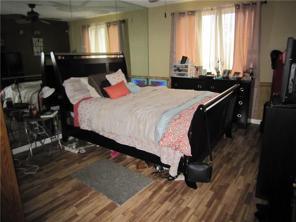 3874 Lyons Road, Unit 2036 Coconut Creek, FL 33073 - Photo 12 of 16 a bedroom with a bed and wooden floor