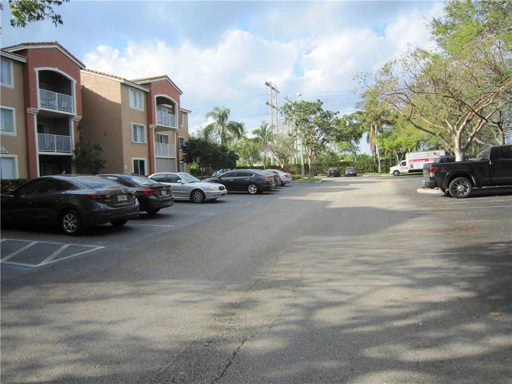 3874 Lyons Road, Unit 2036 Coconut Creek, FL 33073 - Photo 3 of 16 a view of street with parked cars