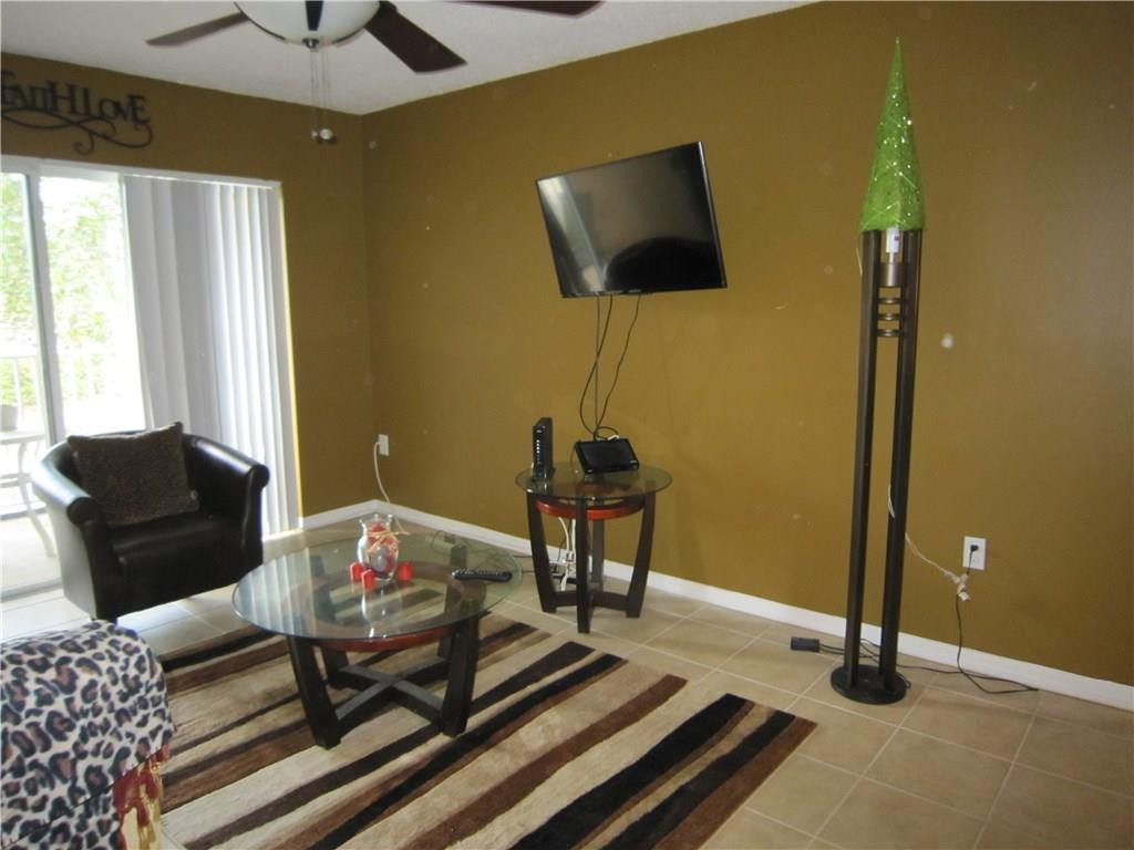 3874 Lyons Road, Unit 2036 Coconut Creek, FL 33073 - Photo 6 of 16 a living room with furniture and a flat screen tv