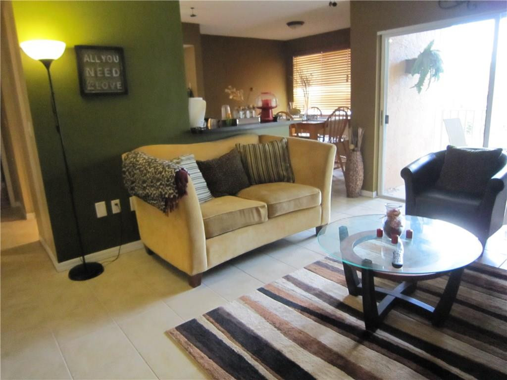 3874 Lyons Road, Unit 2036 Coconut Creek, FL 33073 - Photo 7 of 16 a living room with furniture and a large window