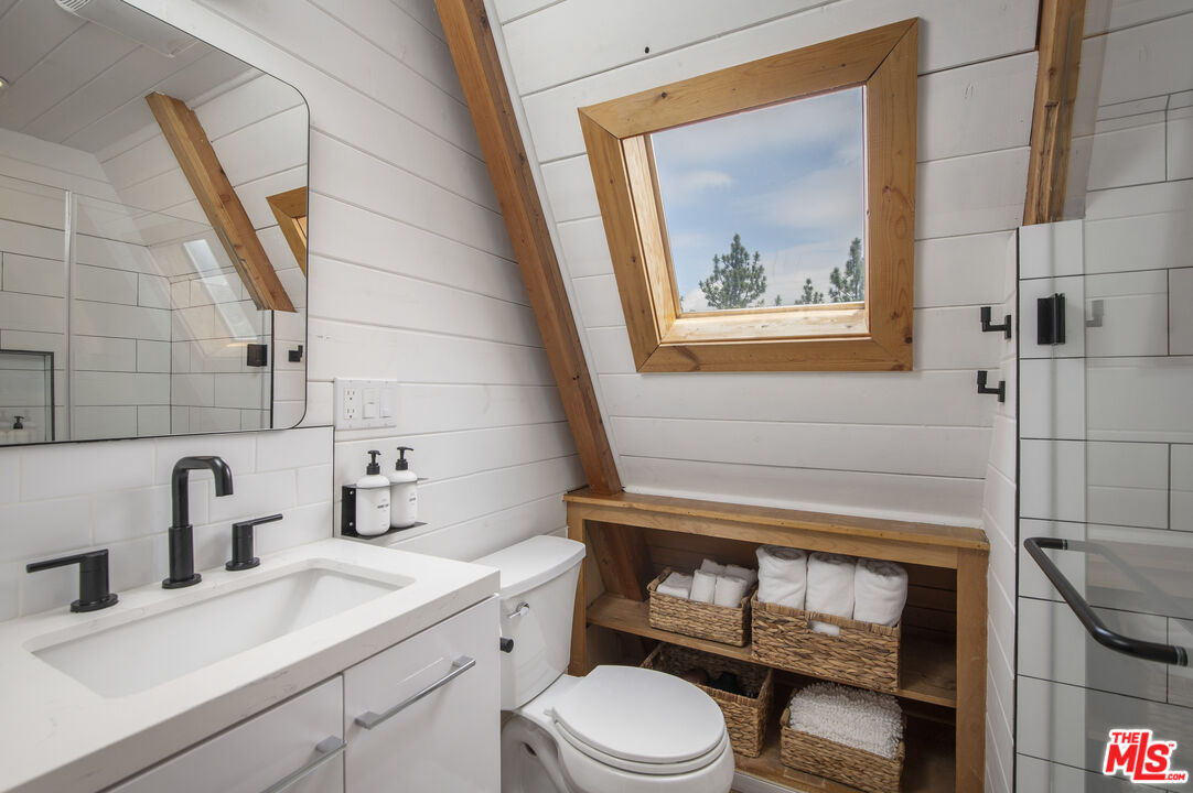 Undisclosed Address Big Bear City, CA 92314 - Photo 24 of 46 a bathroom with a toilet a sink and mirror