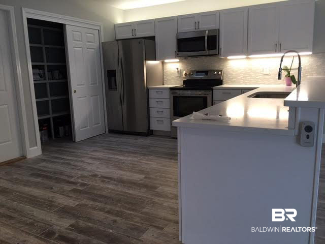 320 West Fort Morgan Road, Unit 103 Gulf Shores, AL 36542 - Photo 2 of 11 White Quartz Countertops. Kenmore stainless appliances.Custom Cabinets with accent lighting