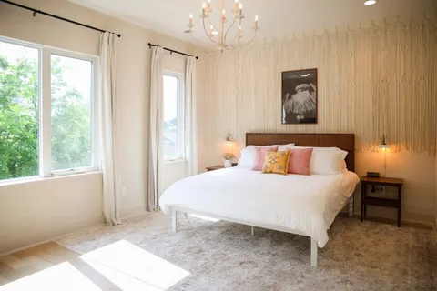 a bedroom with a bed and a chandelier